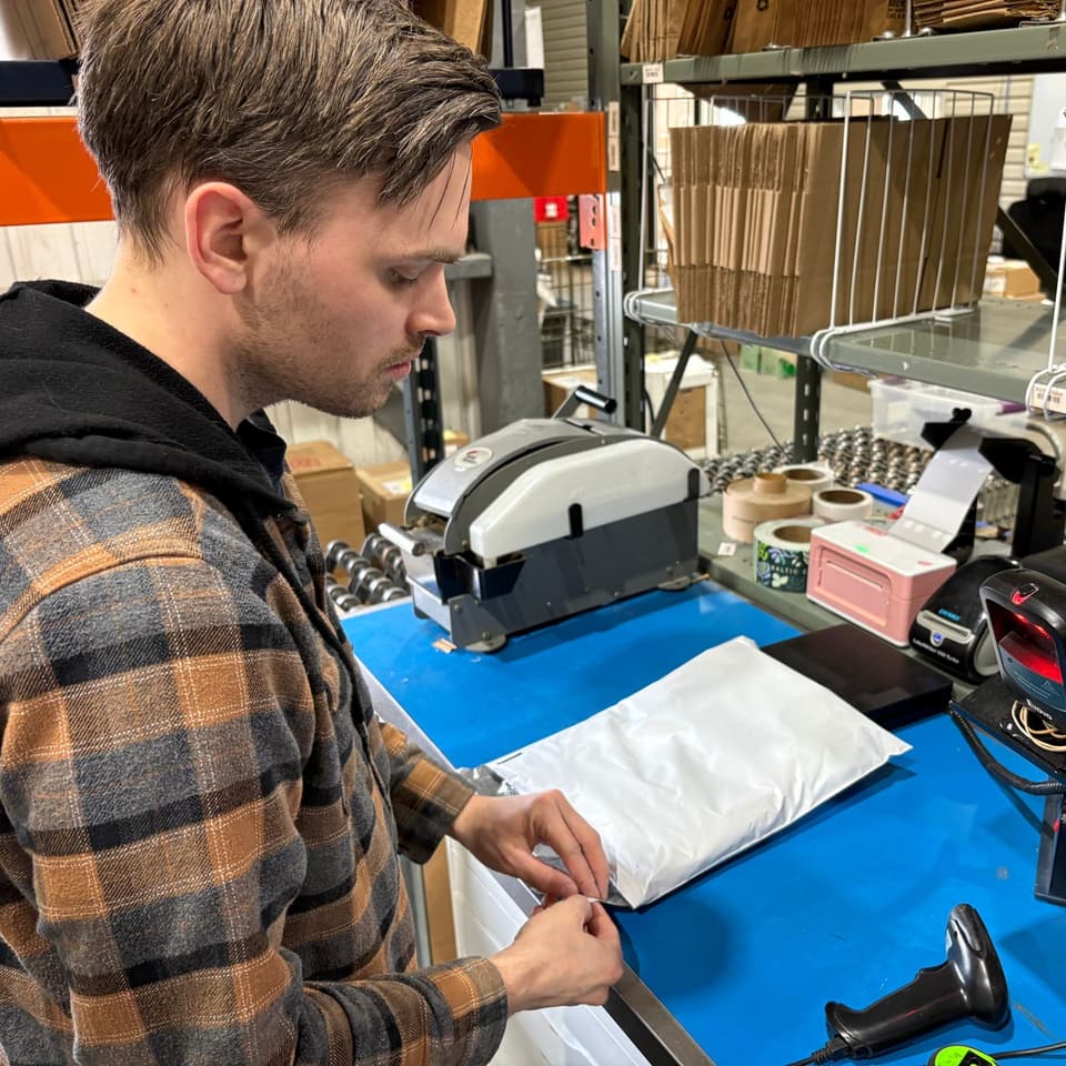 Jonathan St-Denis, co-founder, sealing a shipping mailer at the packing station